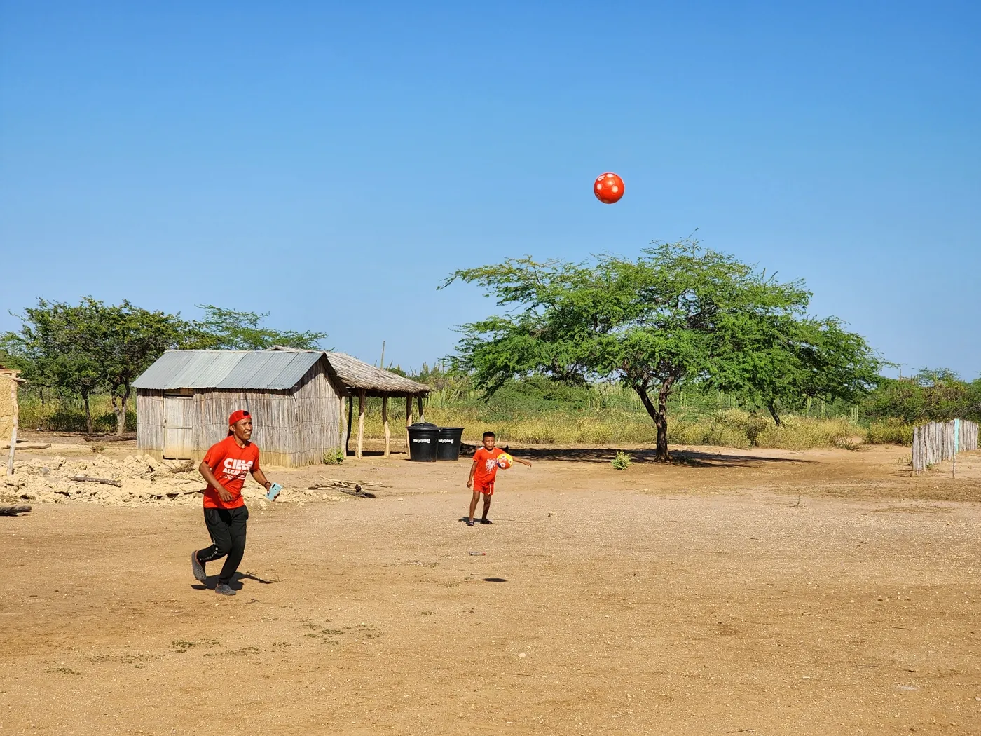 Padre e hijo juegan con un balón entregado en jornada, en su comunidad wayuu de la Alta Guajira