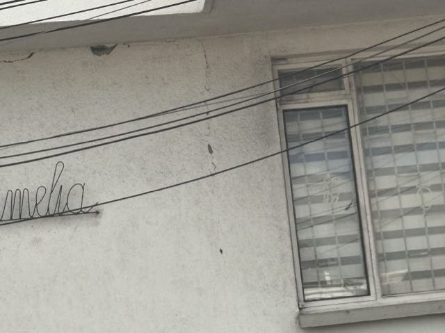 Un muro fotografiado desde abajo y en diagonal, con cables por delante